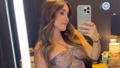 Cynthia Rodríguez posa sonriente frente al espejo luciendo su pancita de embarazada con un vestido floral.