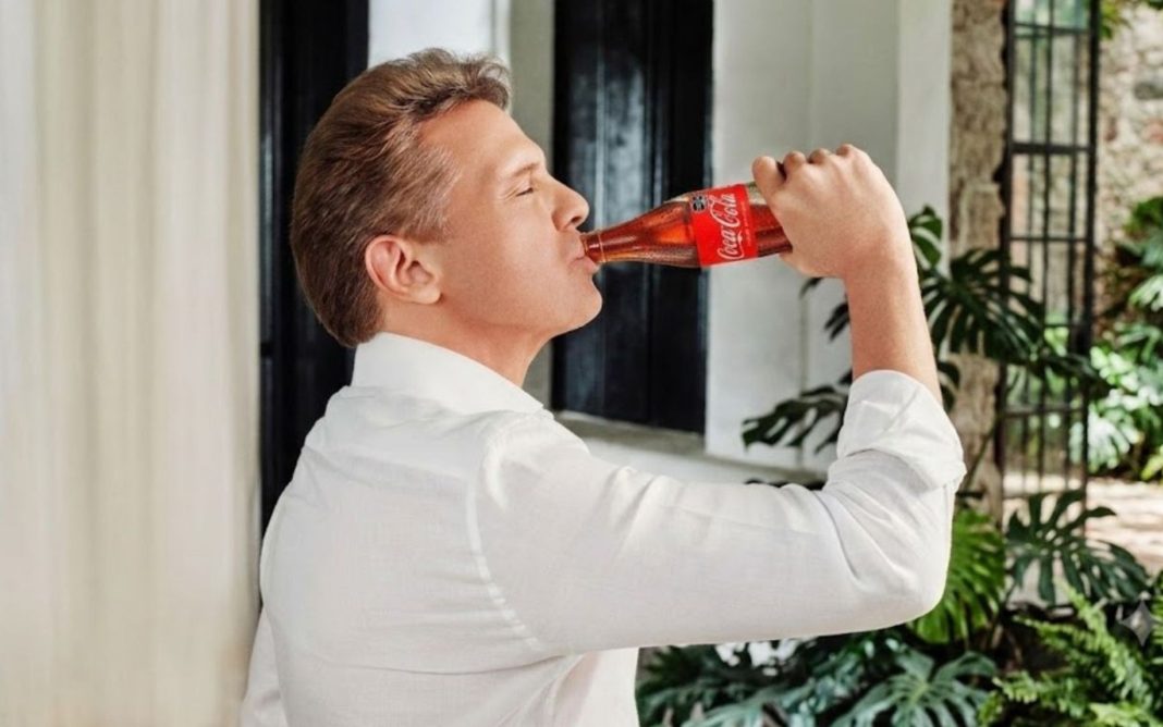 Luis Miguel sonriente luciendo una camisa blanca mientras sostiene una botella de refresco en su reaparición en Instagram