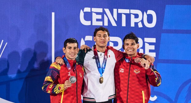 El nadador mexicano Paulo Strehlke sonríe en el podio mostrando sus medallas obtenidas en Santo Domingo.
